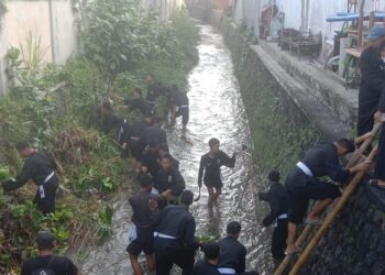 Anggota PSHT Cabang Kota Blitar bersih-bersih sungai, Sabtu (14/6/2025) kemarin. (foto : Aditya/sapablitar.com)